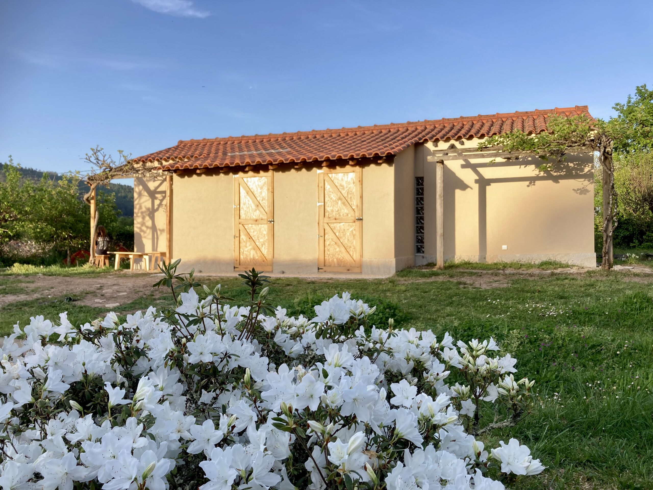 Casa do Lento rodeada por jardim e flores em Covas